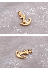 Close-up of golden nautical anchor pendant showing polished metal texture and detail