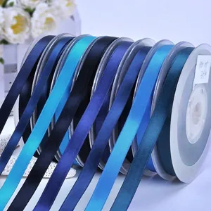 Multiple rolls of 38mm polyester satin ribbon in various blue tones for flower packaging