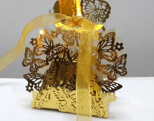 Close-up of golden butterfly laser-cut gift box featuring intricate hollow patterns and ribbon
