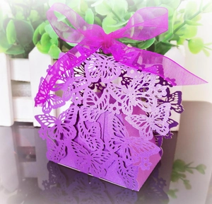 Detail view of purple laser-cut butterfly candy box with a silk ribbon bow and pearl finish