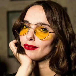 Nahaufnahme der Retro-Sonnenbrille mit gelben Gläsern und dünnem Metallrahmen