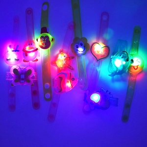 Detailed view of colorful LED glowing slap bracelets with various cute cartoon shapes for night fun.