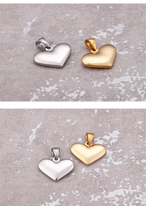 Polished heart pendants in gold and silver finishes on a gray textured stone surface