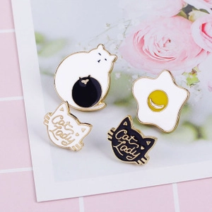 Set of four colorful enamel cat lady pins on a floral pink and white grid background