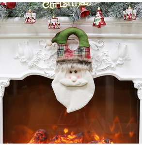 Detail of Santa Claus ornament with green hat and plaid brim by a cozy Christmas fireplace