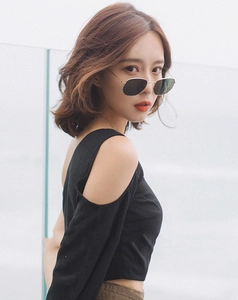 Close-up of retro square metal sunglasses and chic off-shoulder top on fashion model
