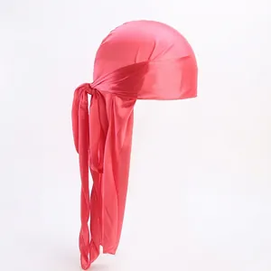Detailed view of pink silky satin durag fabric texture with long tail straps