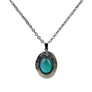 Detailed view of vintage silver floral pendant with oval thermochromic color changing gemstone