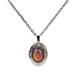 Macro detail of vintage silver locket with floral engravings and oval color-changing stone