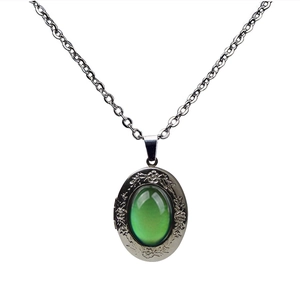 Vintage oval locket necklace with green color-changing gemstone and floral silver frame