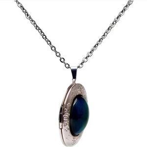 Detail of silver vintage locket with blue gemstone and floral engraving on an O-chain