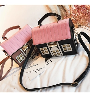 Close-up of house-shaped crossbody bags with creative roof stitching and metal locks