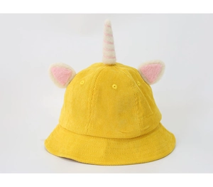 Close-up of yellow corduroy bucket hat featuring a 3D unicorn horn and pink ears
