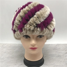 Close-up of purple and light brown striped plush fur winter hat for women