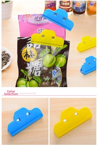 Close-up of cloud-shaped food bag clips in blue and yellow colors on wooden desk