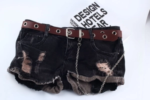 Detail eines Punk-Gürtels mit Ösen und Silberkette auf schwarzen Denim-Shorts