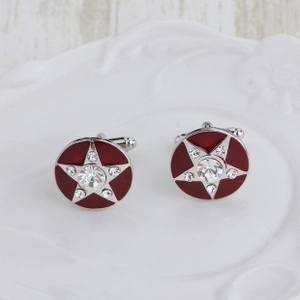 Macro shot of round red enamel cufflinks with silver star and crystal center on display