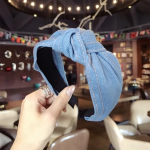 Light blue denim wide knotted headband with classic orange contrast stitching