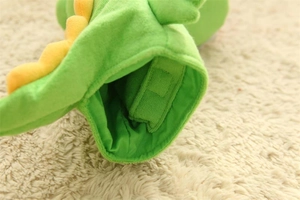 Detail of green plush dinosaur puppet showing soft fabric and adjustable velcro strap
