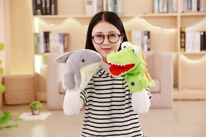 Close-up of plush shark and crocodile hand puppets worn by a woman for storytelling