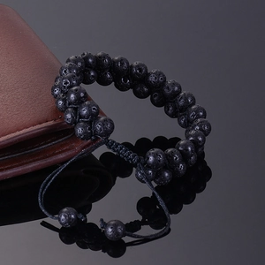Detail of double-layer black lava rock stone bracelet with adjustable braided rope closure