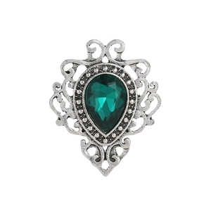 Close-up of vintage silver brooch with teardrop green gemstone and ornate lace detailing