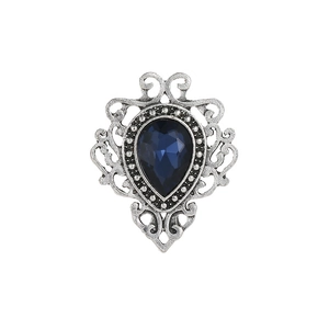 Detail of vintage silver hollow brooch with a central teardrop blue gemstone and diamonds