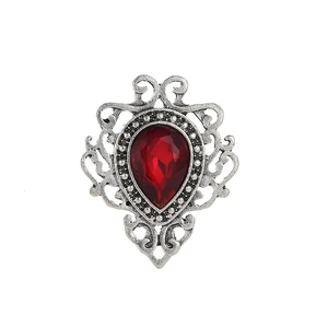 Macro view of retro hollow filigree brooch with a large pear-shaped red gemstone