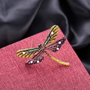 Vintage alloy dragonfly brooch with colorful rhinestones and enamel on a jewelry box