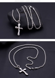 Macro detail of silver stainless steel cross pendant with stylish rope chain necklace
