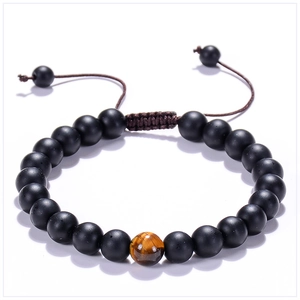 Detail of 8mm matte black beads and tiger eye stone on adjustable braided bracelet