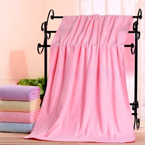 Detail of pink microfiber bath towel with embossed bear patterns and soft velvet texture