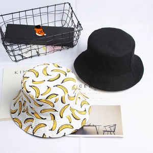 Reversible canvas bucket hat set featuring solid black and yellow banana fruit print patterns