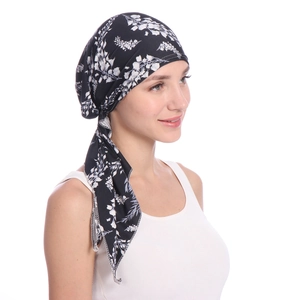 Side view of black headscarf with white floral print and elegant side drape on model