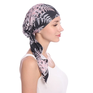 Detail of floral printed headscarf with pink and white leaf patterns on black fabric