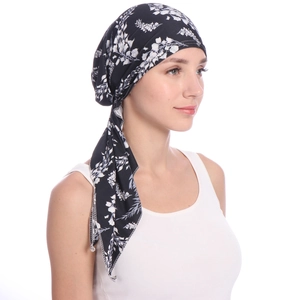 Detail of printed turban cap with white floral pattern on black soft fabric