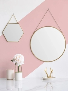 Close-up of geometric gold brass mirrors in round and hexagonal shapes with chains