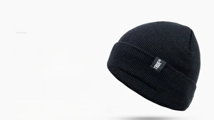 Detailed view of black beanie with fine knit texture and TRUE brand logo patch