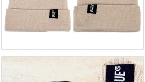 Macro detail of beige knit beanie showing the premium texture and black True logo label