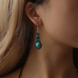 Gros plan sur les boucles d'oreilles bohème en turquoise et motifs argentés vintage