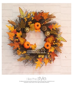 Détail d'une couronne d'automne avec feuilles d'érable, mini citrouilles et pommes de pin