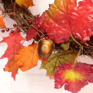 Autumn wreath with red maple leaves berries and golden acorn on rustic vine base
