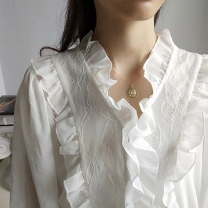 Elegant 925 sterling silver sun pendant necklace in gold finish on white lace shirt