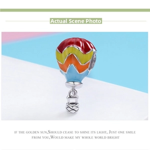 Macro shot of 925 silver hot air balloon charm with colorful enamel and woven basket