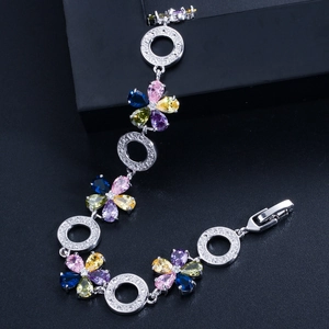 Nahaufnahme glitzernder bunter Zirkonia-Blumen auf einem silbernen floralen Armband