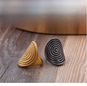 Macro detail of fine steel shield rings with 18K gold plating and spiral rope texture