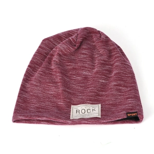 Detail of burgundy knitted beanie showing textured fabric and white ROCK patch label