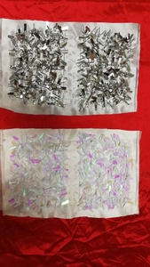 Detail of handmade rectangular sequin patches in metallic silver and iridescent white tones