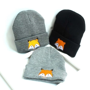 Détail de bonnets d'aviateur en tricot gris et noir avec broderie renard enfant
