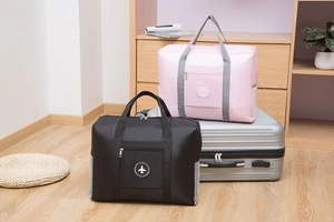 Foldable travel bag detail showing pink and black waterproof oxford fabric on luggage
